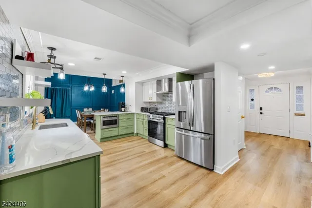 a kitchen with stainless steel appliances kitchen island granite countertop a refrigerator and a stove