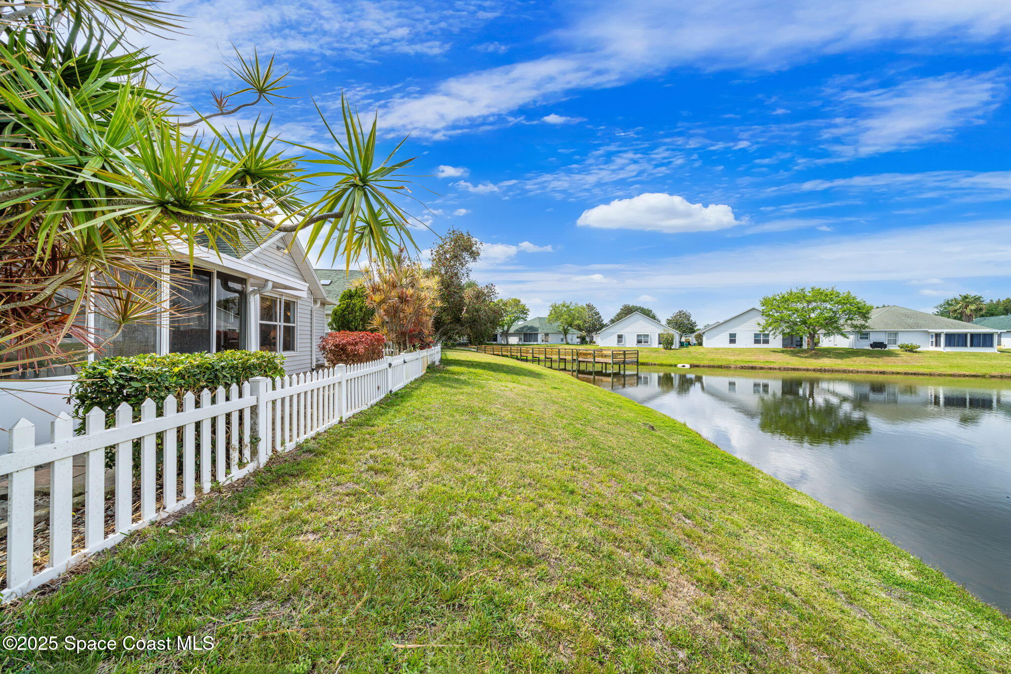 3847 Town Square Boulevard, Unit 30 Melbourne, FL 32901 - Photo 12 of 36 a view of a lake with a house in the background