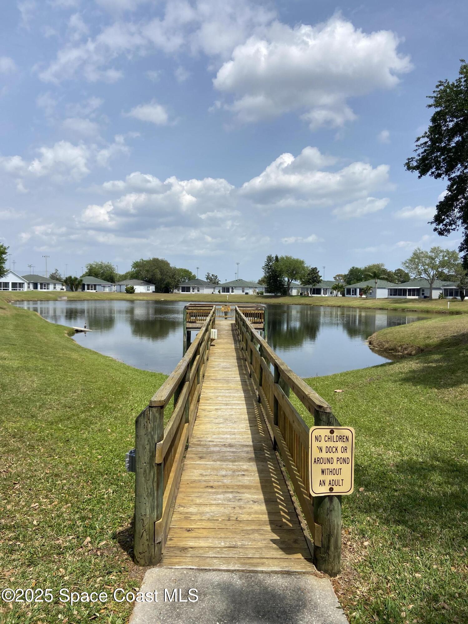 3847 Town Square Boulevard, Unit 30 Melbourne, FL 32901 - Photo 17 of 36 a view of a lake with a table and chairs
