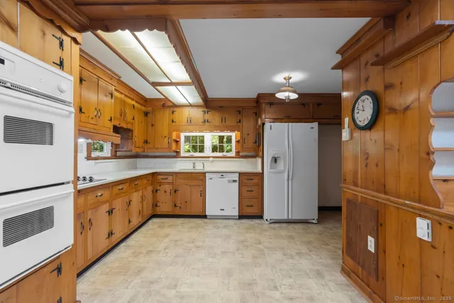 a large kitchen with a refrigerator a stove top oven a sink and dishwasher
