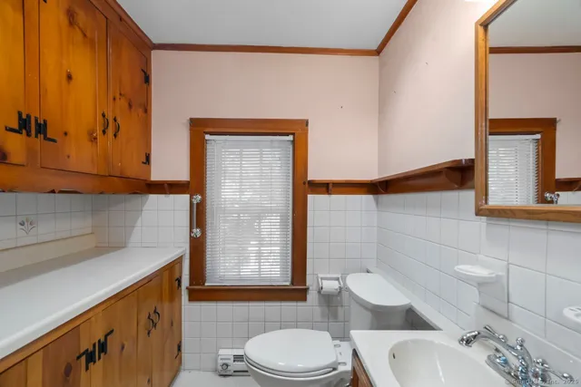 a bathroom with a sink toilet and window