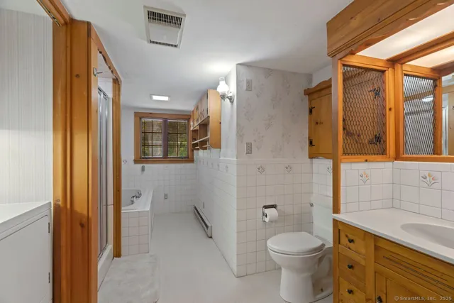 a bathroom with a granite countertop toilet a sink and a shower