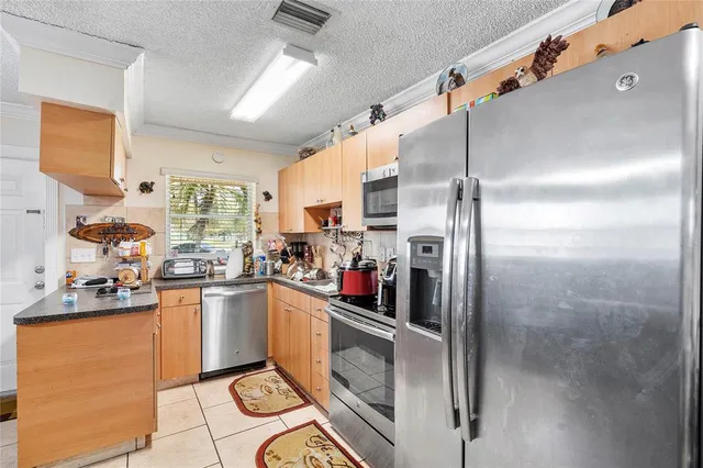 a kitchen with stainless steel appliances granite countertop a refrigerator and a stove