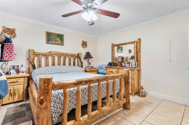 a bedroom with furniture and a chandelier fan