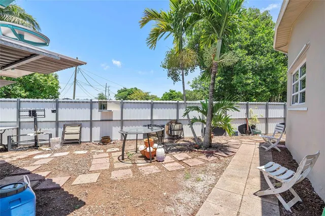 a view of a patio with a dining table and chairs with wooden floor