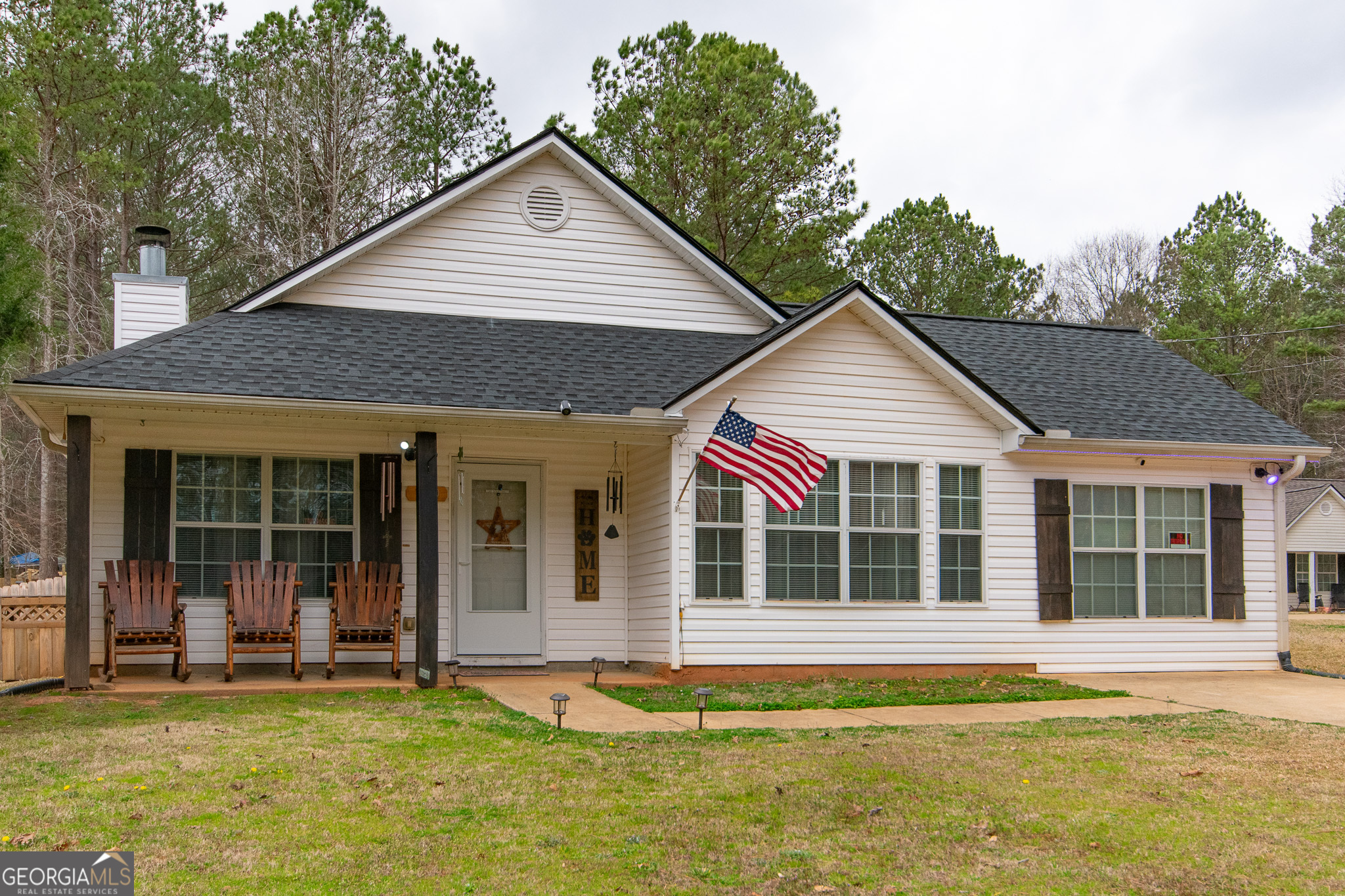 109 Jenny Road Grantville, GA 30220 - Photo 1 of 1 a view of a white house with a large windows and a yard with plants and a outdoor view