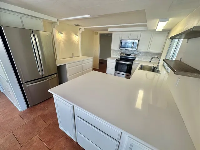 a kitchen with stainless steel appliances a refrigerator and a stove