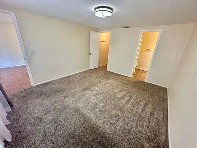 an empty room with windows and closet