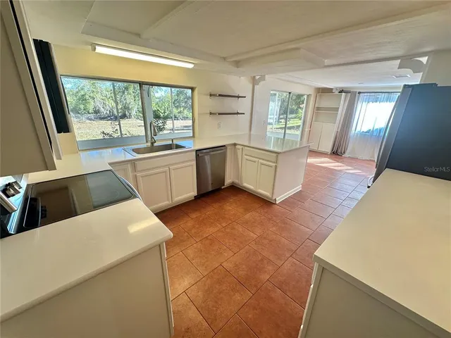 a large white kitchen with a large window
