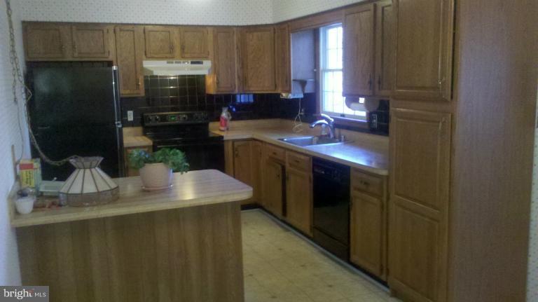 5002 Long Beach Road St. Leonard, MD 20685 - Photo 2 of 27 a kitchen with a sink a stove and refrigerator