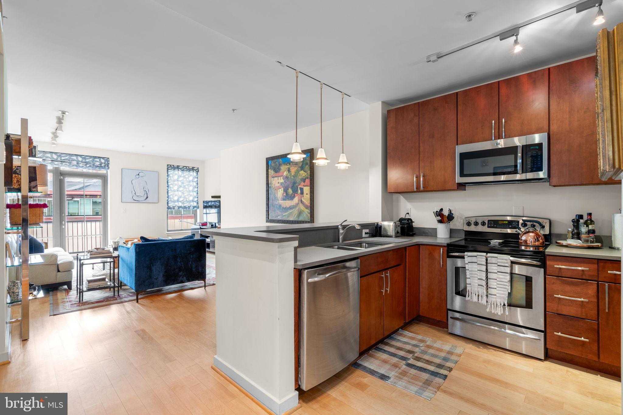 2412 17th Street Northwest, Unit 301 Washington, DC 20009 - Photo 11 of 18 a kitchen with stainless steel appliances granite countertop a stove top oven a sink dishwasher and a microwave oven on the blue kitchen countertops