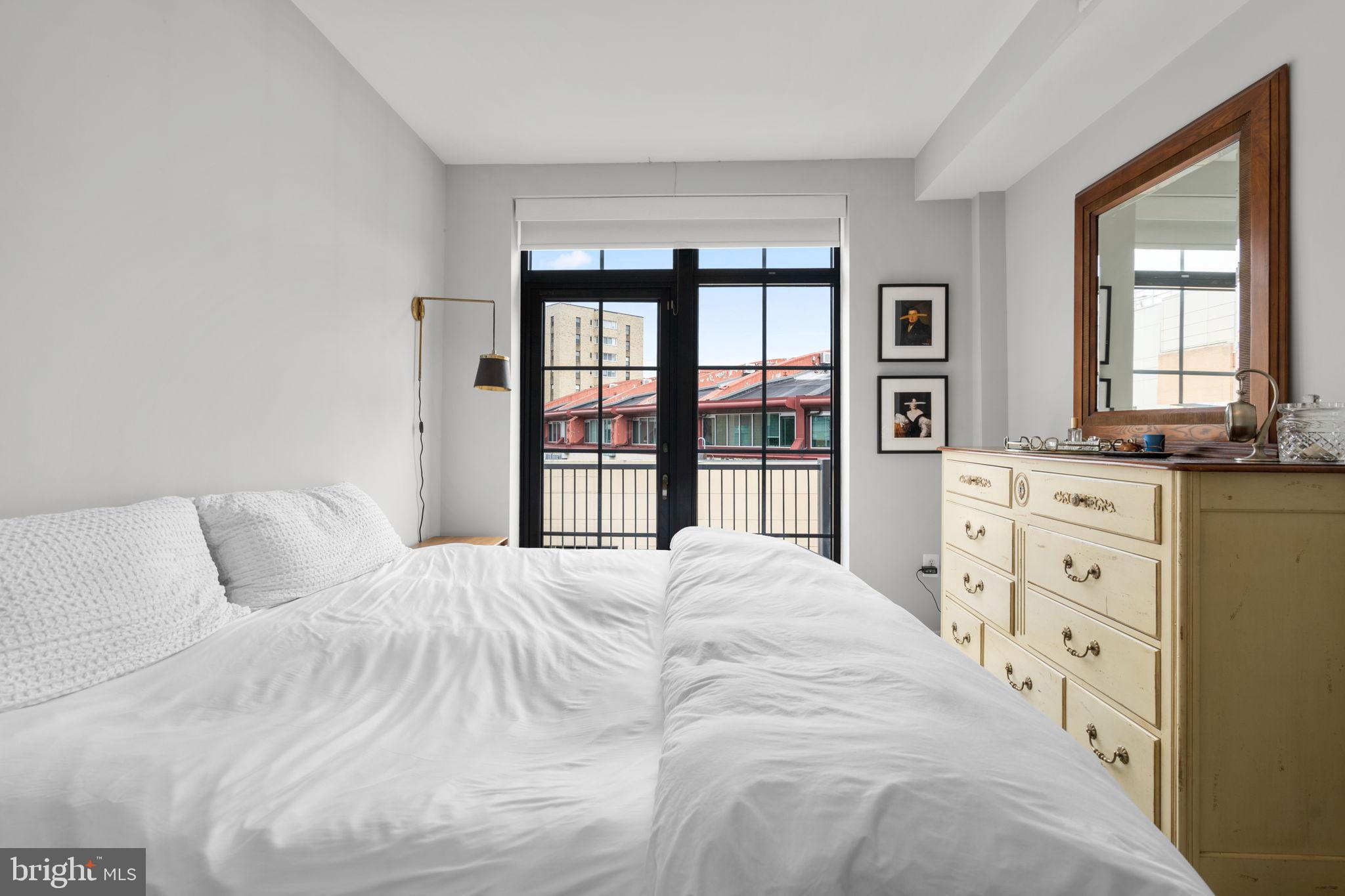 2412 17th Street Northwest, Unit 301 Washington, DC 20009 - Photo 13 of 18 a large bed sitting in a bedroom next to a window