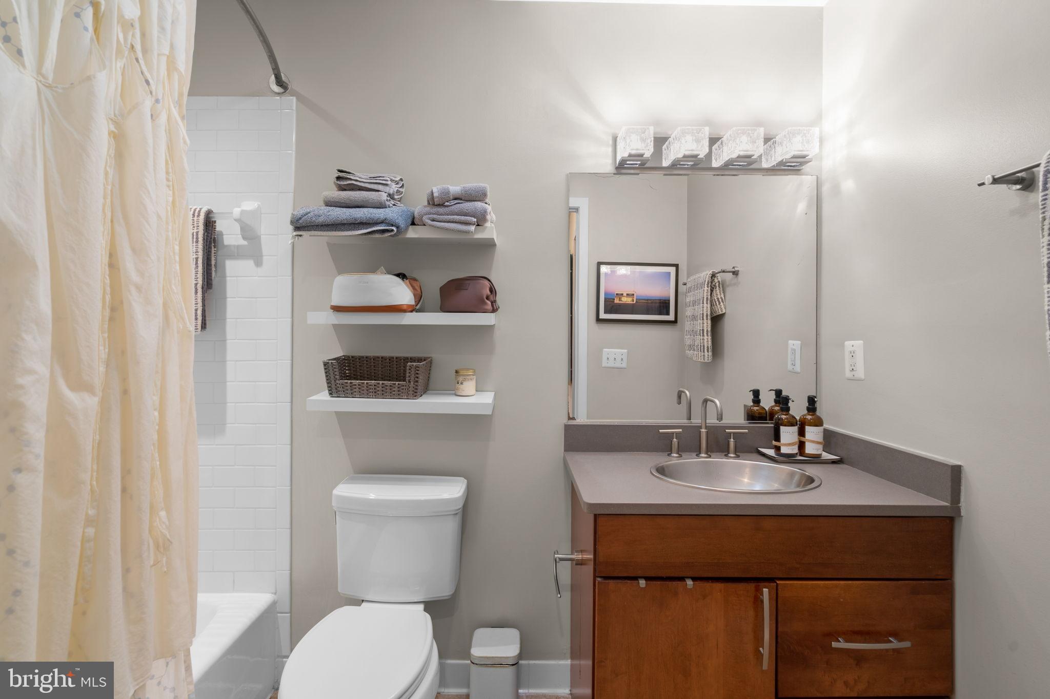 2412 17th Street Northwest, Unit 301 Washington, DC 20009 - Photo 16 of 18 a bathroom with a toilet a sink and mirror