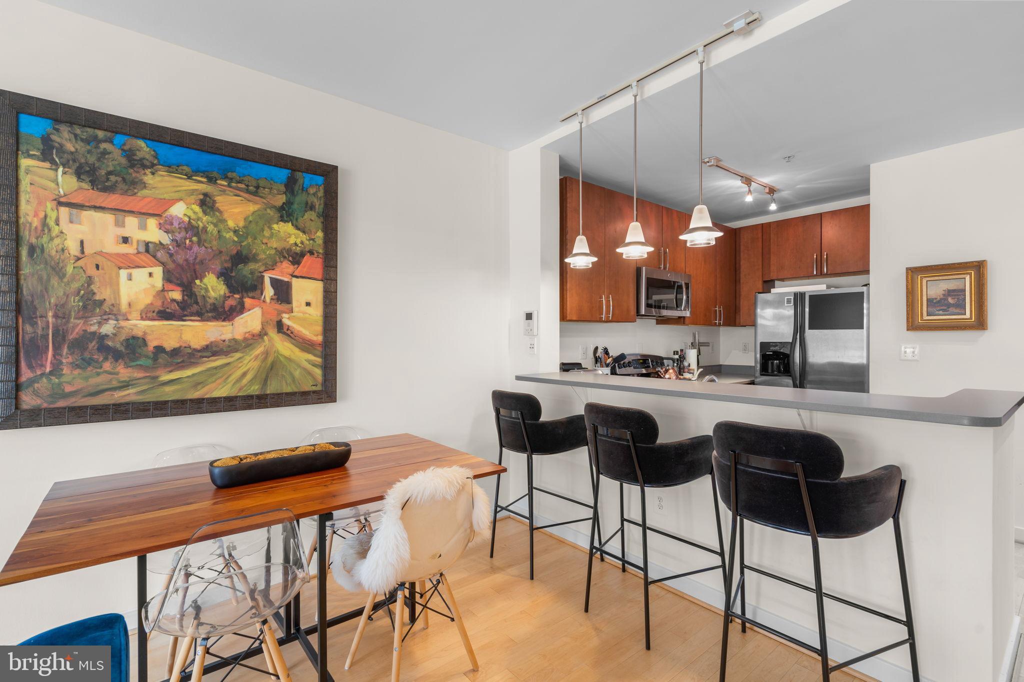 2412 17th Street Northwest, Unit 301 Washington, DC 20009 - Photo 7 of 18 a view of a dining room with furniture a kitchen and chandelier