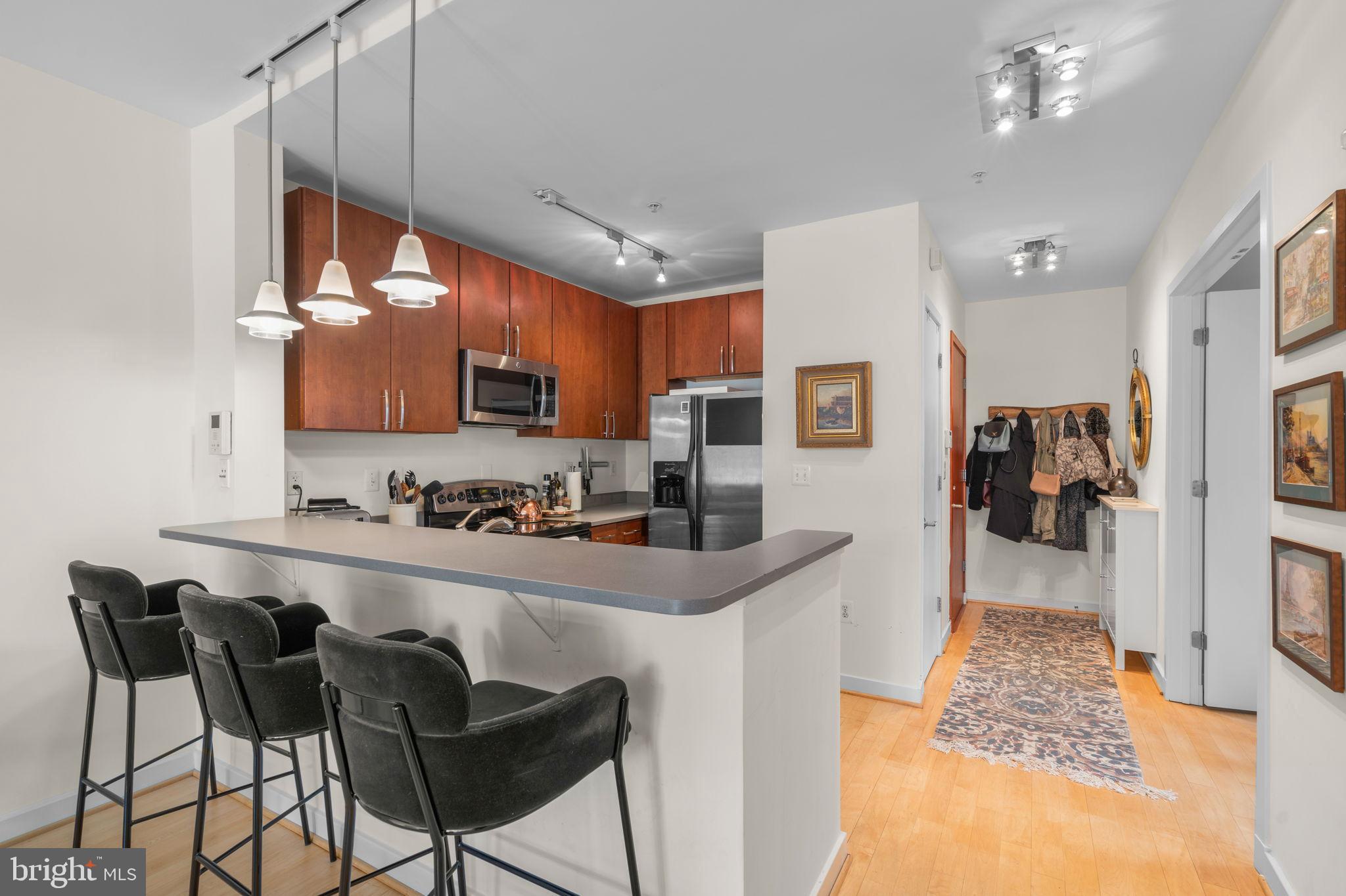 2412 17th Street Northwest, Unit 301 Washington, DC 20009 - Photo 9 of 18 a kitchen with granite countertop a table chairs refrigerator and microwave