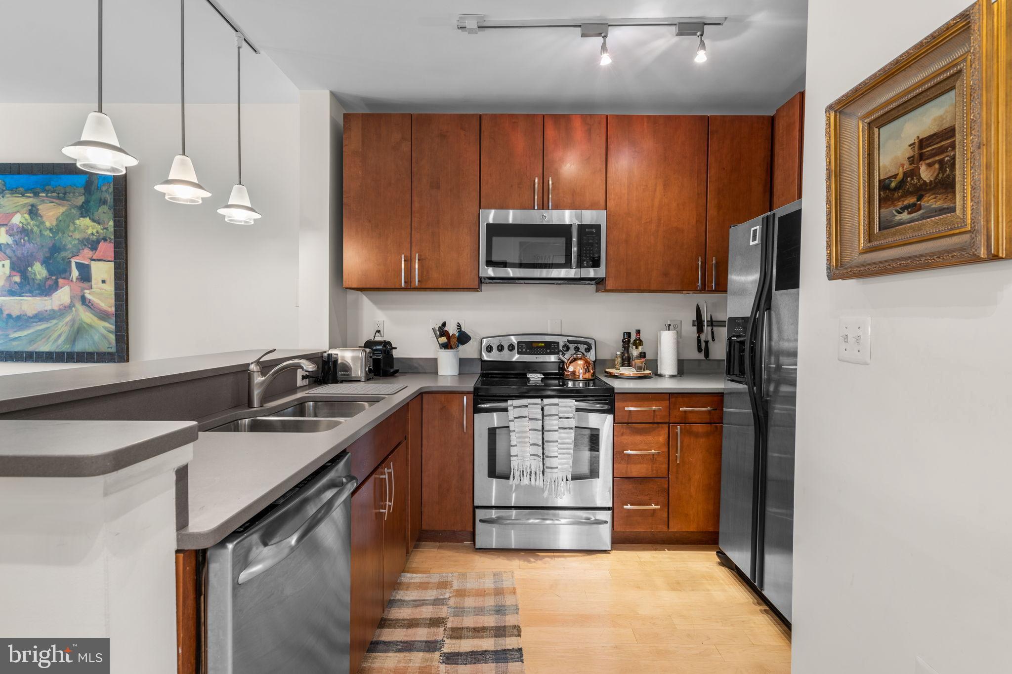 2412 17th Street Northwest, Unit 301 Washington, DC 20009 - Photo 10 of 18 a kitchen with stainless steel appliances granite countertop a sink stove and microwave