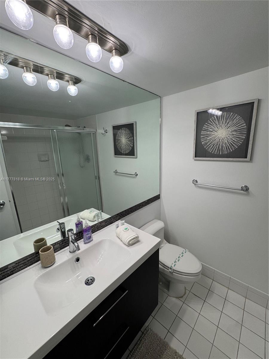 5161 Collins Avenue, Unit 1206 Miami Beach, FL 33140 - Photo 16 of 28 a bathroom with a sink mirror and toilet