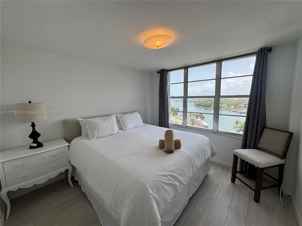 a large bedroom with a bed and large windows