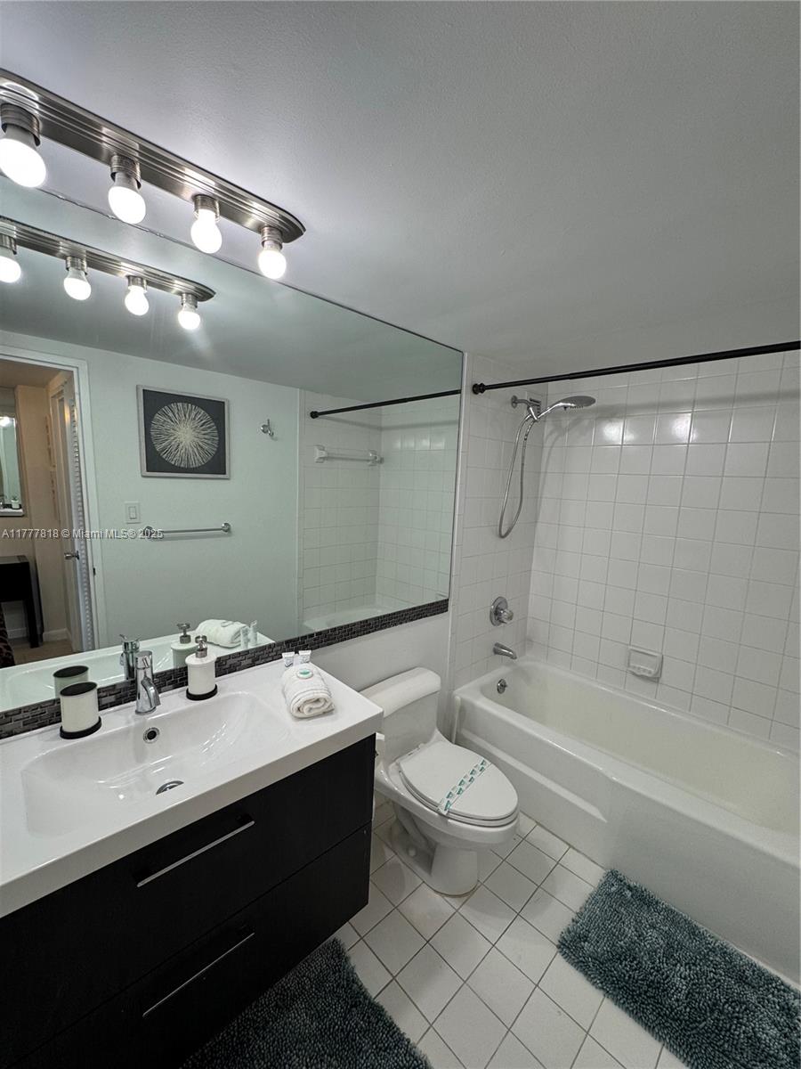 5161 Collins Avenue, Unit 1206 Miami Beach, FL 33140 - Photo 19 of 28 a bathroom with a double vanity sink toilet mirror and bathtub
