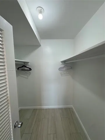 a view of kitchen with wooden floor and cabinets