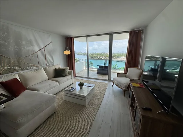 a living room with furniture and a floor to ceiling window