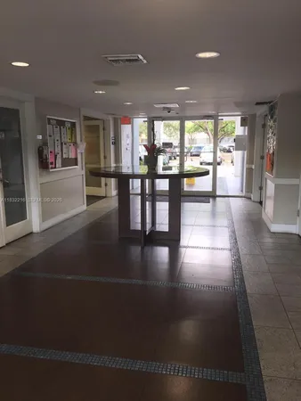 a front view of a building with streets and trees