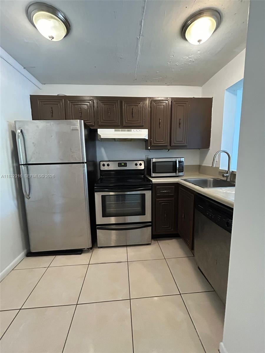 496 Northwest 165th Street, Unit D310 Miami, FL 33169 - Photo 2 of 16 a kitchen with a sink a refrigerator and a stove