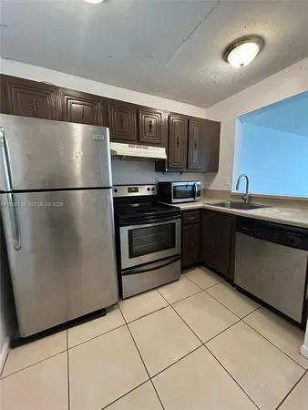 a kitchen with stainless steel appliances granite countertop a refrigerator a sink a stove a microwave and a counter top