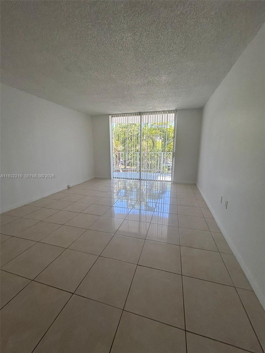 496 Northwest 165th Street, Unit D310 Miami, FL 33169 - Photo 4 of 16 a view of an empty room with a window