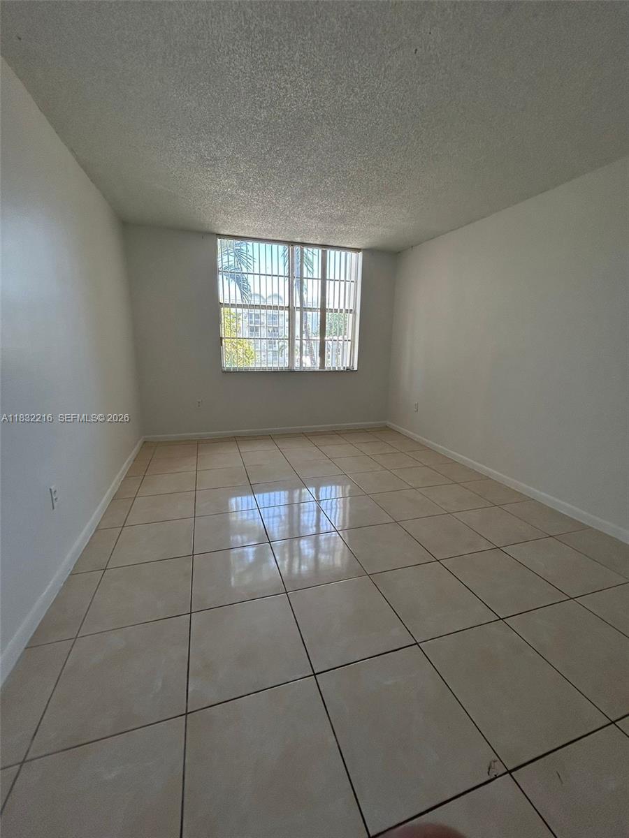 496 Northwest 165th Street, Unit D310 Miami, FL 33169 - Photo 7 of 16 a view of an empty room with a window