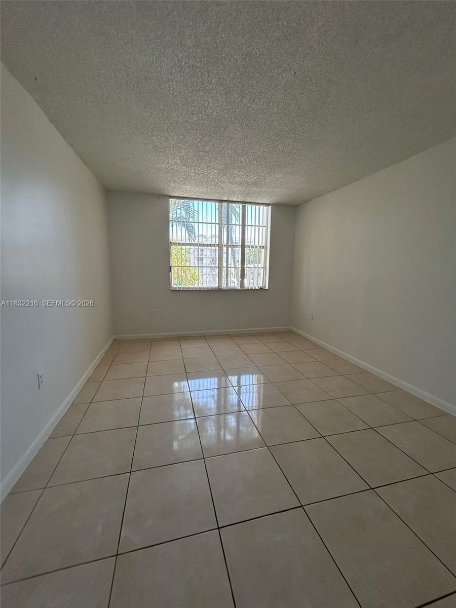 496 Northwest 165th Street, Unit D310 Miami, FL 33169 - Photo 9 of 16 en empty room with windows