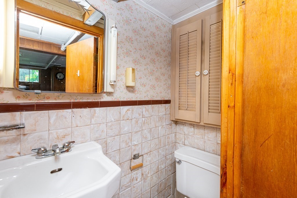 9 Linnea Lane Reading, MA 01867 - Photo 28 of 33 a bathroom with a sink a toilet and mirror
