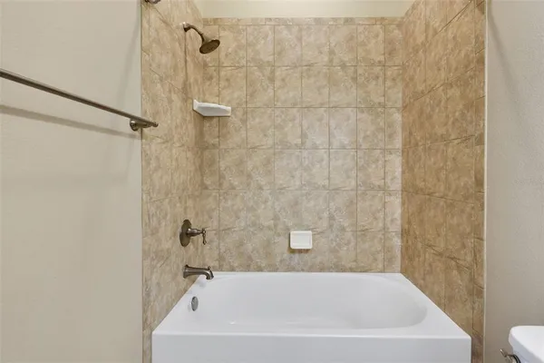 a bathroom with a white bath tub a shower and a sink