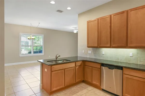 a kitchen with stainless steel appliances granite countertop a sink a stove cabinets and a window