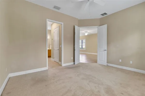 an empty room with closet and a chandelier fan