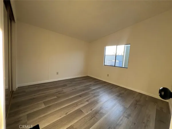 a view of a room that has wooden floor and windows in it