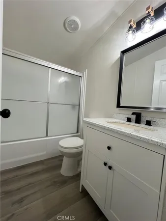 a bathroom with a toilet a sink a mirror and shower