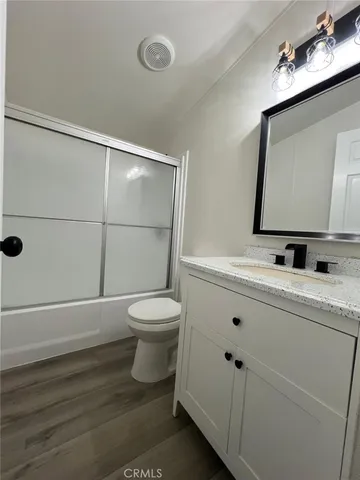 a bathroom with a toilet a sink a mirror and shower