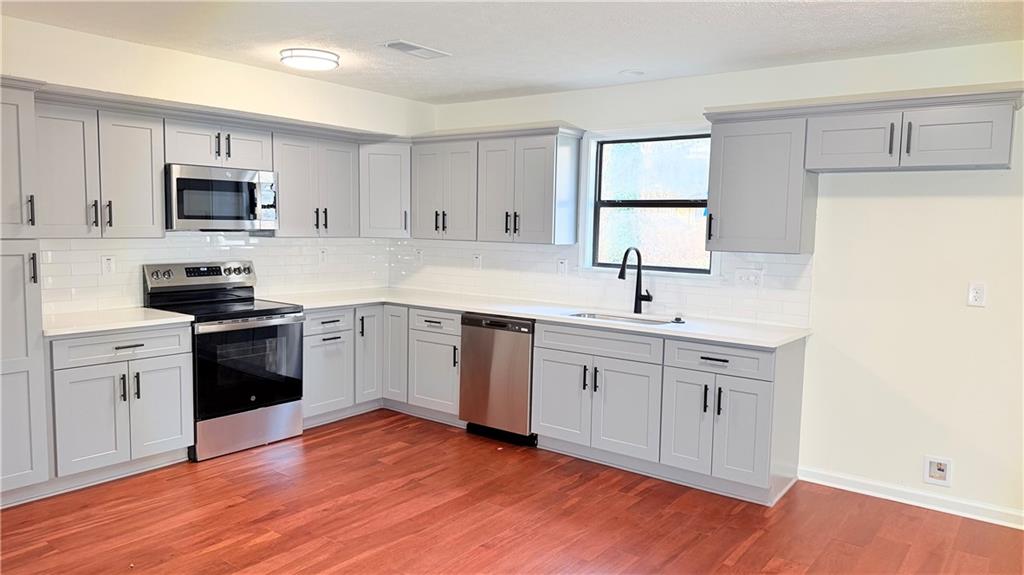5257 Post Ridge Court Stone Mountain, GA 30088 - Photo 12 of 42 a kitchen with white cabinets appliances and sink