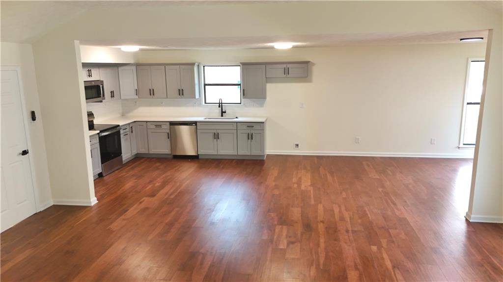 5257 Post Ridge Court Stone Mountain, GA 30088 - Photo 15 of 42 a large kitchen with a hard wood floor stainless steel appliances and a window