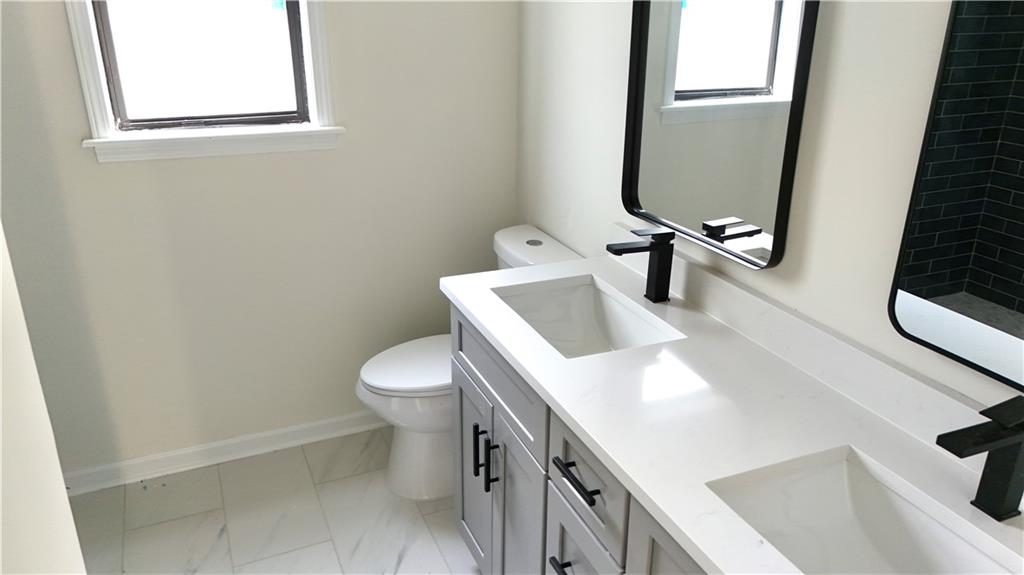 5257 Post Ridge Court Stone Mountain, GA 30088 - Photo 25 of 42 a bathroom with a sink a toilet and a mirror