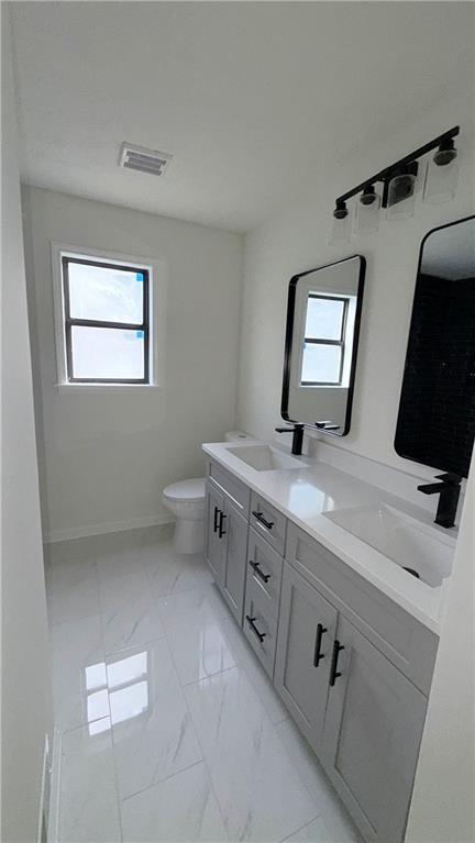 5257 Post Ridge Court Stone Mountain, GA 30088 - Photo 26 of 42 a bathroom with a double vanity sink a toilet and a mirror