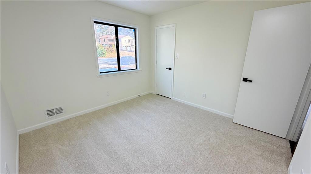 5257 Post Ridge Court Stone Mountain, GA 30088 - Photo 28 of 42 an empty room with windows and closet