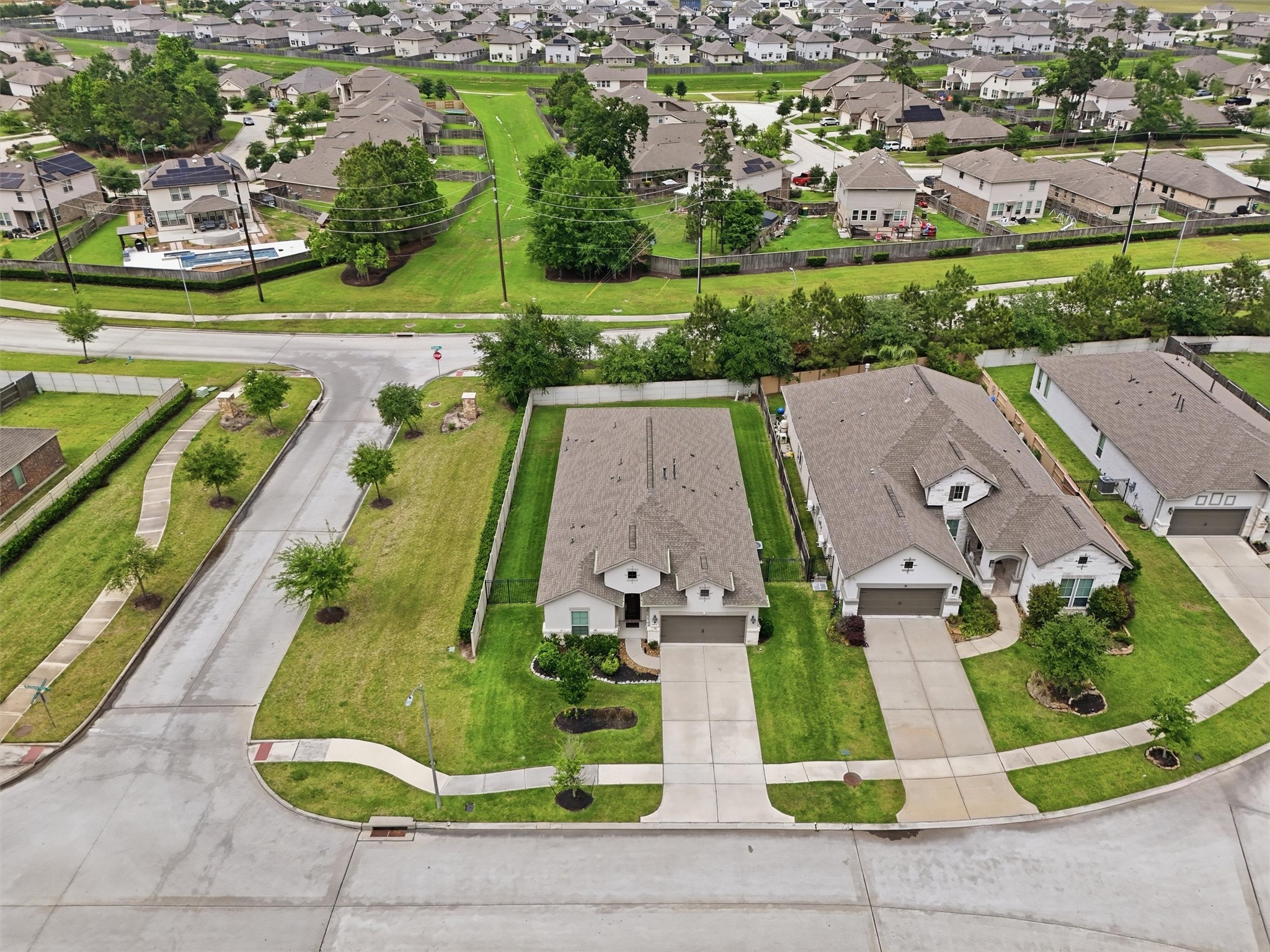 6071 Windward Falls Way Porter, TX 77365 - Photo 28 of 33 This aerial photo showcases a quiet suburban neighborhood with single-family homes featuring spacious driveways and well-maintained lawns. The area has winding streets, ample greenery, and a community feel, perfect for family living.