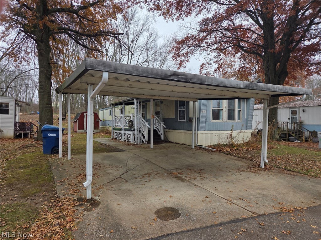 7443 Spillway Road, Unit 58 Lisbon, OH 44432 - Photo 2 of 15 View of front of house with concrete driveway and a storage shed