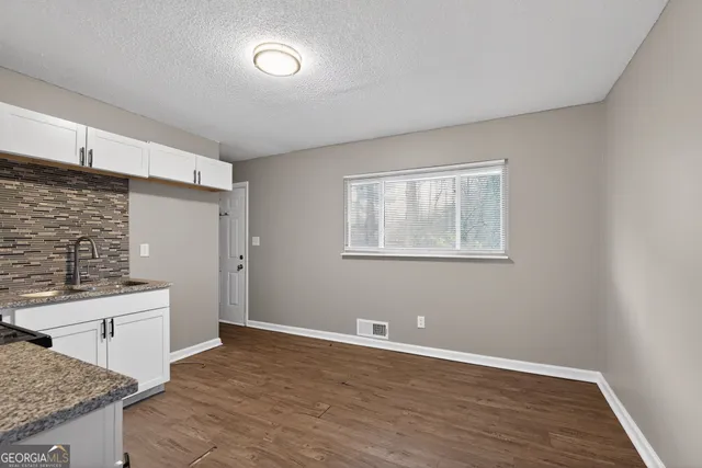 a view of a kitchen with wooden floor and a sink