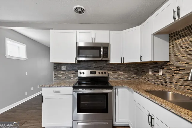 a kitchen with stainless steel appliances granite countertop a stove and a microwave