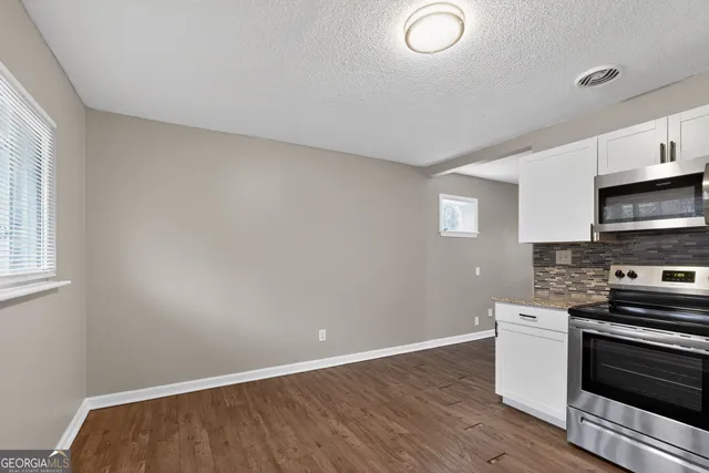 a view of kitchen with wooden floor and electronic appliances