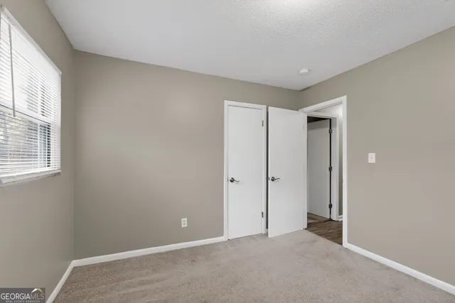 an empty room with windows and closet