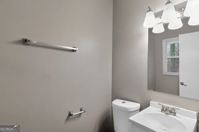 a bathroom with a toilet a sink and mirror